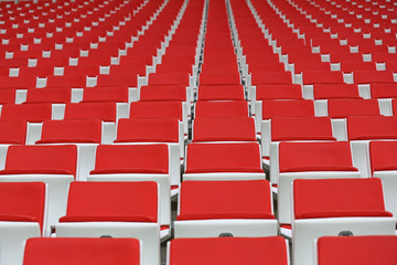 Obraz premium Czerwone fotele dla kibiców na sektorze trybuny nowoczesnego stadionu piłkarskiego