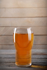 Glass of apple juice on wooden background