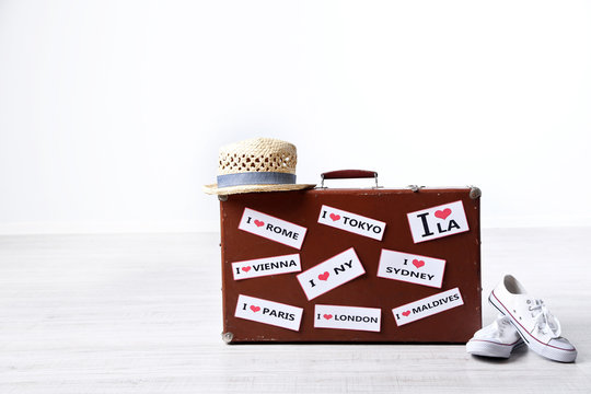 Suitcase with stickers on floor in room