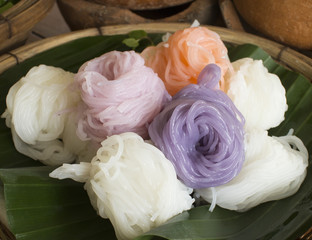 Pastel colored Thai rice noodle on banana leaf in the wooden basket