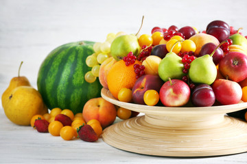 Heap of fresh fruits and berries on wooden background