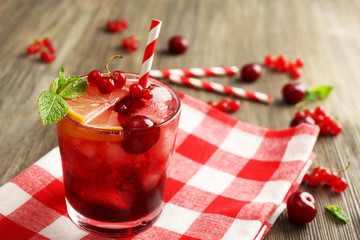 Glass of berry juice on wooden table, closeup