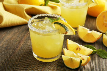 Glasses of lemon juice on wooden table, closeup