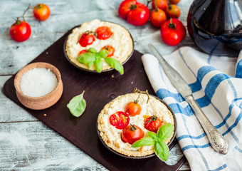 quiche with goat cheese, cherry tomatoes and basil on blue woode
