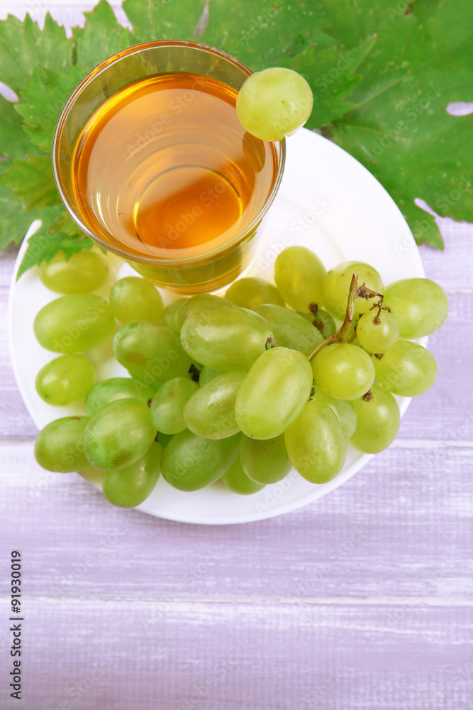 Poster glass of grape juice on wooden table, closeup