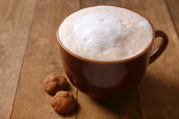 Cup of coffee and biscuits on wooden background