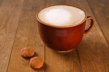 Cup of coffee and biscuits on wooden background
