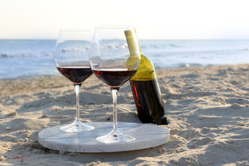Wine bottle and glasses on the seashore