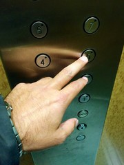 doigt appuyant sur un bouton d'ascenseur