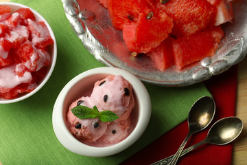 Watermelon ice cream in bowls and fresh watermelon pieces  on color wooden background
