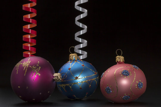 Christmas decoration with colorful balls and ribbons on black