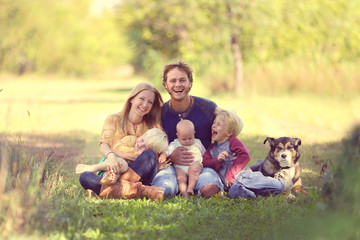 Happy Family Laughing Together with Dog Outside