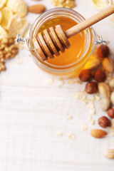 Honey in glass jar and nuts. Country breakfast concept