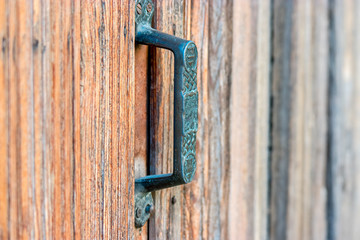 Door handle on obsolete wooden background.
