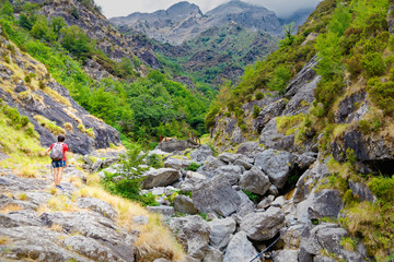 Lonely girl follows a hiking trail in a Tuscan valley