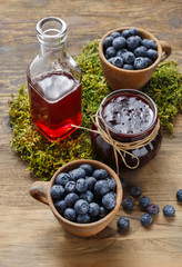 Jar of blueberry jam and bowls of blueberries