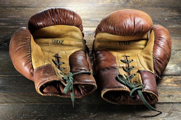 alte Boxhandschuhe auf rustikalem Holzhintergrund
