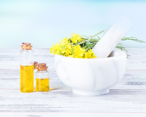 Rape oil and flower on wooden table