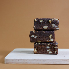 Delicious chocolate brownie cakes on chopping board on brown background. (#1)