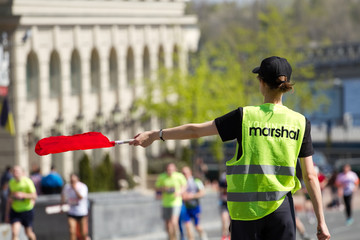 Volunteer Marshal shows the direction of runners
