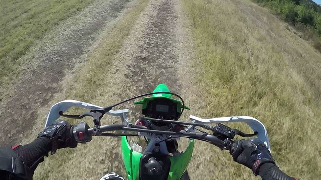 Point of View: Enduro biker riding motorcycle on dirt track action camera mounted on the chest