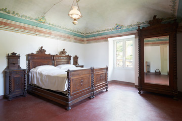 Wooden bedroom in ancient house with fresco