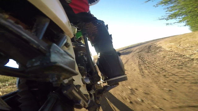  Enduro racer riding bike on dirt track rear wheel point of view