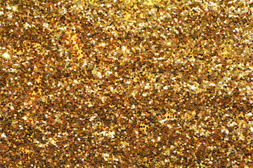 Holiday yellow glitter, gold sand and dust texture. Golden sparkling background. Orange brown metallic surface. 