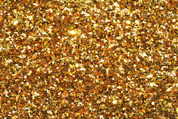 Gold sand and dust texture. Golden sparkling glitter background. Metallic surface. 