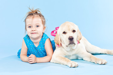 Little girl are playing with labrador 