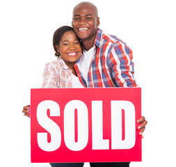 african couple showing sold sign