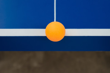 pingpong ball hits the edge of a blue pingpong table