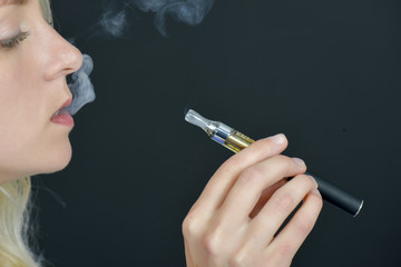 Fototapeta premium Blond woman smoking an electronic cigarette