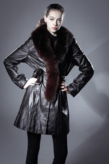 Portrait of a beautiful young woman with fur coat in studio