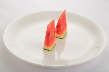 Organic  Slices of watermelon inWhite plate on white background