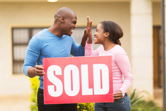 young african couple celebrating their house been sold