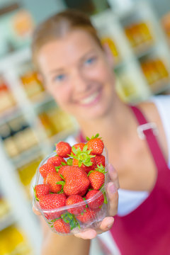 Supermarket worker holding some strawberries