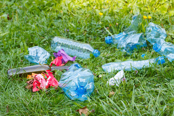 Heap of rubbish on grass in park, littering of environment
