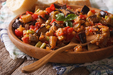 Sicilian Caponata with aubergines closeup on wooden plate. horizontal
