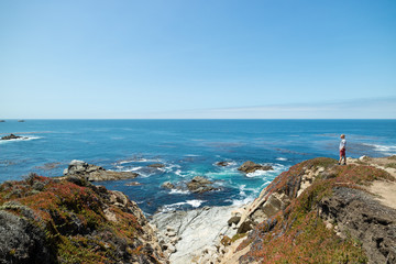 Man standing at contemplating life looking at beautiful coastal view along the Pacific Coast Highway Route 1, California, United States