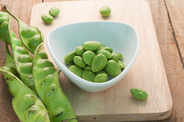 Bitter bean on the white dish and wood floors.