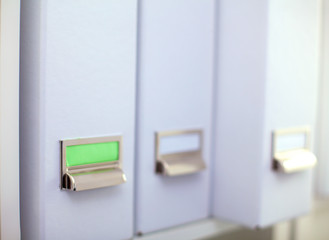 File folders, standing on  shelves in the background