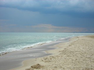 Long exotic sandy beach on a cloudy day with dramatic sky. Beautifu beach landscape.