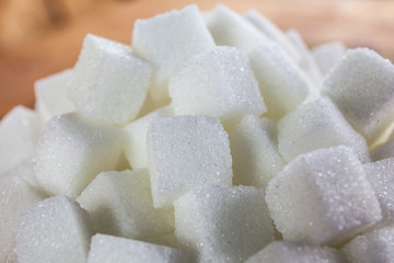 Pile of Sugar Cubes over Wooden Background