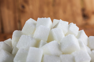 Pile of Sugar Cubes over Wooden Background
