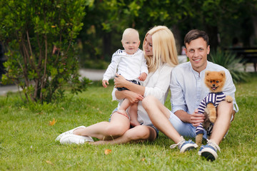 Naklejka na ściany i meble Happy young family spending time together in green nature