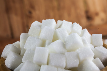 Pile of Sugar Cubes over Wooden Background