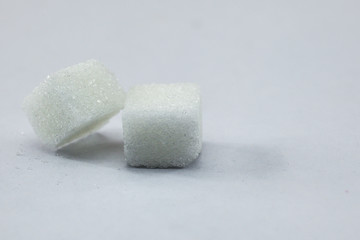 Sugar Cubes on Isolated White Background with Harsh Shadow, which can be used to imply dark side of Sugar