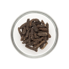 Top view of Organic Long pepper Dried Fruit (Piper longum) half filled in glass bowl isolated on white background.