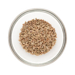 Top view of Organic Ajwain (Trachyspermum ammi) half filled in glass bowl isolated on white background.